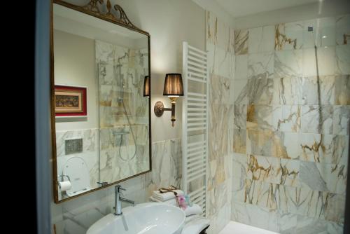 ein Bad mit einem Waschbecken und einem Spiegel in der Unterkunft Mamo Florence - La Galerie Luxury Apartment in Florenz