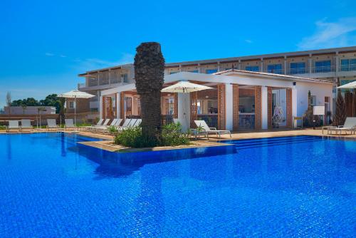 a hotel with a large swimming pool in front of a building at Radisson Blu Resort Saidia Beach in Saidia 