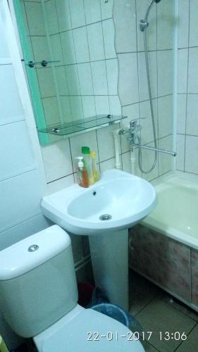 a bathroom with a toilet and a sink and a shower at Zavenyagina 4 Apartment in Noril'sk