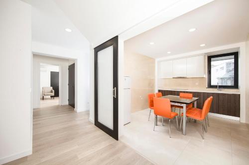 a kitchen and dining room with orange chairs and a table at XA Apartments RRAL-579 in Madalena
