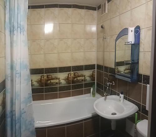 a bathroom with a sink and a bath tub at Apartment Zavenyagina 2 in Noril'sk