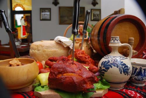 a table topped with meat and other food items at Crama Haiducilor in Cluj-Napoca