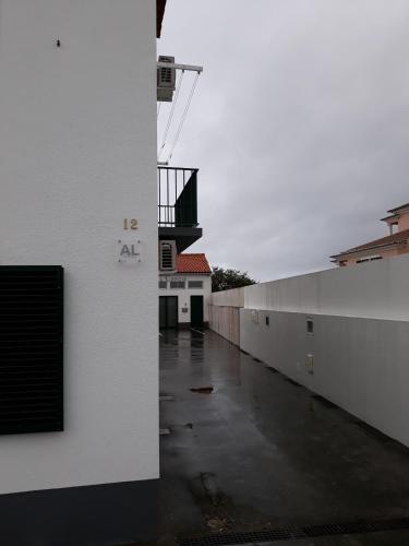 an empty alley with a white wall and a building at Apartamento Valados in Ponta Delgada