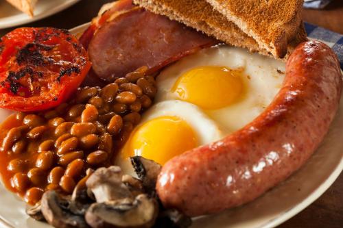 a plate of breakfast food with eggs sausage beans and toast at Shendish Manor Hotel & Golf Course in Hemel Hempstead