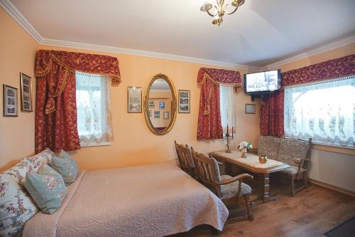 a bedroom with a bed and a table and a desk at Pokoje Gościnne Gazda in Polanica-Zdrój
