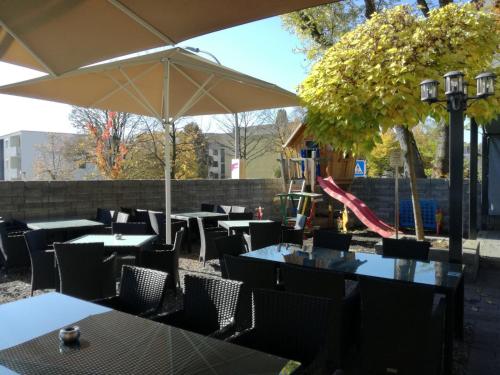 un restaurante al aire libre con mesas y sombrilla en Gaststätte Peperoni en Biberach an der Riß