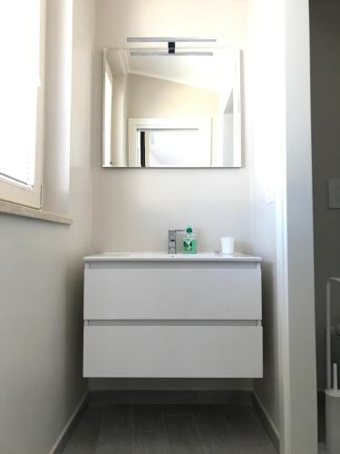 a bathroom with a white sink and a mirror at Il Nido - Miniattico panoramico by AppartamentiPetrucci in Foligno