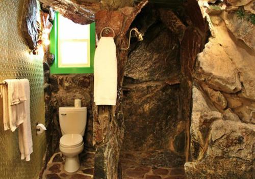 a stone bathroom with a toilet and a window at Madonna Inn in San Luis Obispo