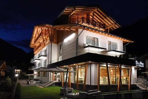 un edificio con la fachada iluminada por la noche en Dolomeet Boutique Hotel, en Pinzolo