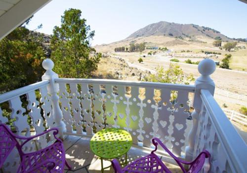 a balcony with two chairs and a view of a mountain at Madonna Inn in San Luis Obispo
