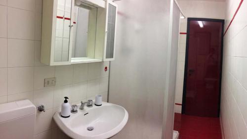 a white bathroom with a sink and a mirror at Studio CENTRAL 1 in Aosta