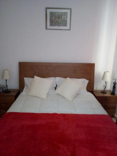 アルヴォルにあるApartamento Bela Vistaのベッドルーム1室(赤と白のベッド1台、ランプ2つ付)