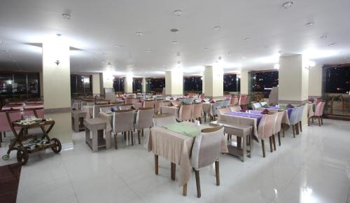 a dining room with tables and chairs in a restaurant at Grand Corner Boutique Hotel in Izmir