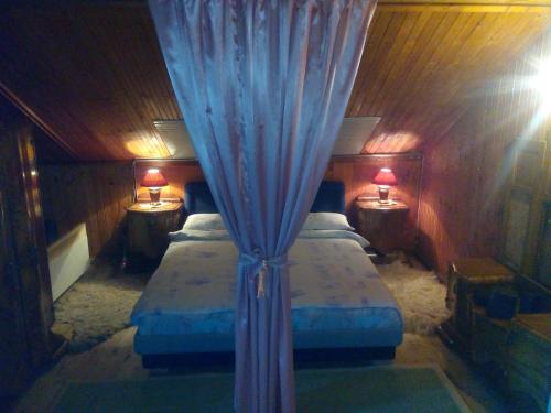 a bedroom with two beds with blue curtains and two lamps at Holiday Home Nature Neno in Visoko