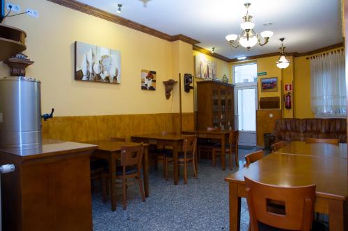 comedor con mesas y sillas de madera en Hotel Los 14 en Pravia