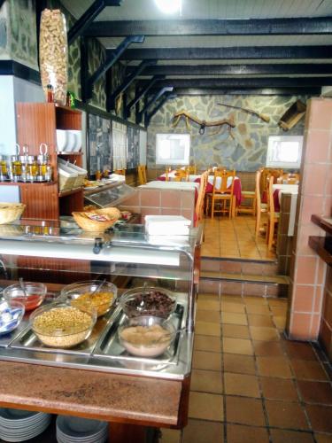 Un restaurante con línea de buffet con mesas y sillas. en Hotel Montesol Arttyco, en Sierra Nevada