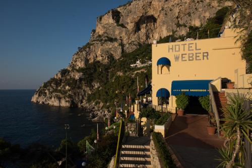 a hotel on the side of a mountain next to the ocean at Hotel Weber Ambassador in Capri