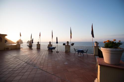 a patio with a view of the ocean with flags at Hotel Weber Ambassador in Capri