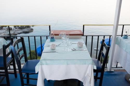 a table with a white table cloth and glasses on a balcony at Hotel Weber Ambassador in Capri