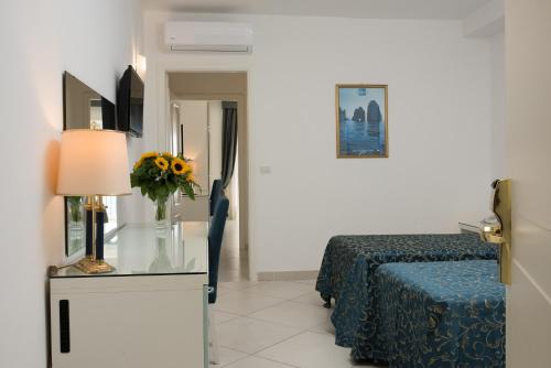 a bedroom with a bed and a table with a lamp at Hotel Weber Ambassador in Capri