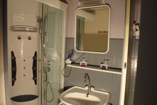 uma casa de banho com um WC, um lavatório e um espelho. em Taverne de la paix em La Ferté-Macé