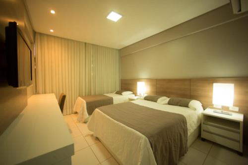 um quarto de hotel com duas camas e duas lâmpadas em Salgueiro Plaza Hotel em Salgueiro