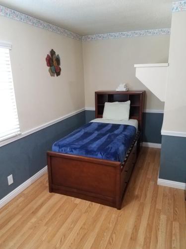 a bedroom with a bed with a blue blanket on it at Travelers Bed & Breakfast Hostel in Las Vegas