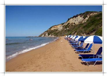 Una fila de sillas de playa con sombrillas en una playa en Adriatica View, en Vitalades