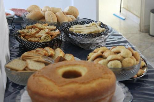 a table topped with bowls of different types of pastries at Hotel Nacional Montes Claros in Montes Claros