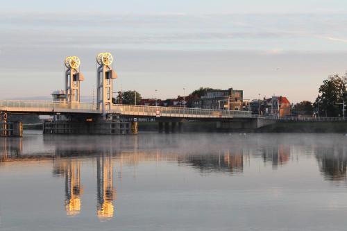 a bridge over a river with fog on the water at Hotel van Dijk in Kampen