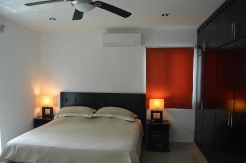 a bedroom with a bed with two night stands and two lamps at Casa Mango in Valladolid
