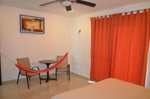 a room with a hammock and a table and chairs at Casa Mango in Valladolid