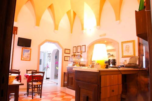 eine Küche mit gewölbten Decken sowie einem Tisch und Stühlen in der Unterkunft Albergo Vittoria in Taviano