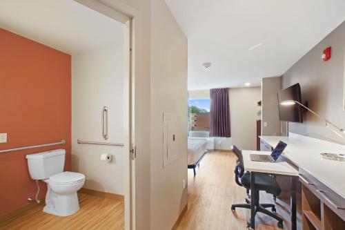 a bathroom with a toilet and a desk with a computer at Extended Stay America Premier Suites - Providence - East Providence in East Providence