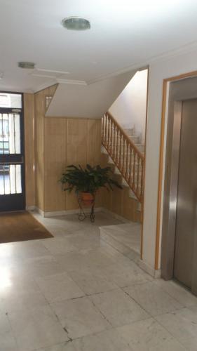 a hallway with a plant in a room with a staircase at Hostal Juanito in Móstoles