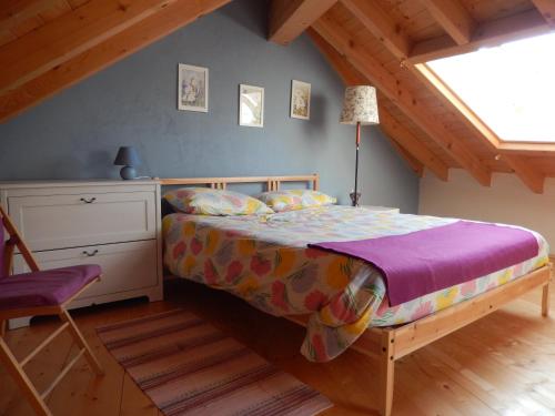 1 dormitorio con 1 cama y 1 silla en el ático en Casa delle Antiche Pietre, en Cannero Riviera