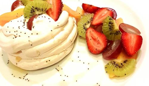 a white plate with a cake with strawberries and kiwis at Bosch Hoek Golf & Lodge in Balgowan