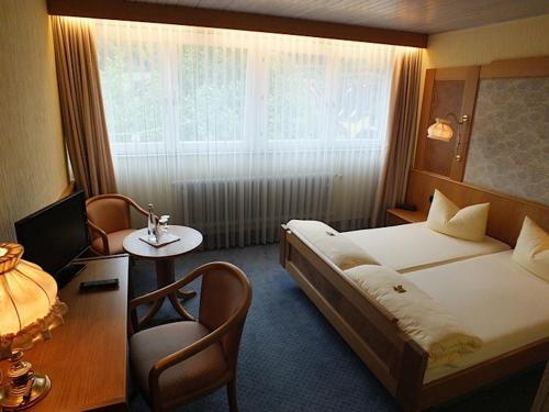 a bedroom with a bed and a desk and a chair at Achkarrer Krone in Achkarren