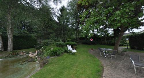 a garden with chairs and a table and a table and chairs at Logis Hôtel-Restaurant La Croix Couverte in Mayenne
