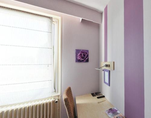 a room with a desk with a window and a table at Logis Hôtel-Restaurant La Croix Couverte in Mayenne