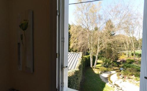 an open window with a view of a yard at Logis Hôtel-Restaurant La Croix Couverte in Mayenne