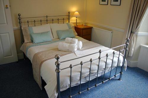 a bedroom with a large bed with white sheets and blue pillows at Brixham House in Brixham