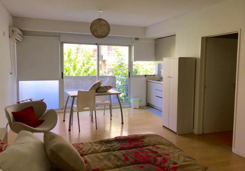 a living room with a table and a kitchen at Ocio Laprida in Buenos Aires