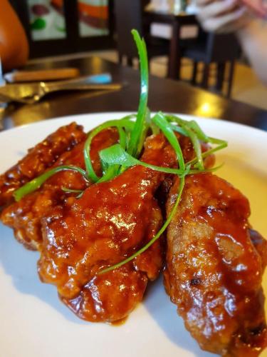 two pieces of meat with sauce on a white plate at Hotel Plaza in Santiago