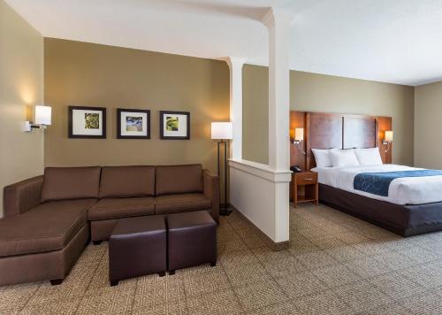 Comfort Suites Hartville-North Canton في Uniontown: غرفه فندقيه بسرير واريكه