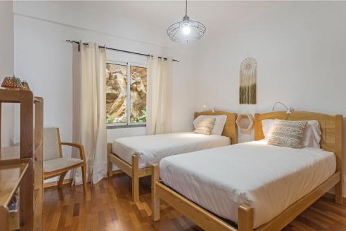 カニコにあるReis Magos II by An Island Apartのベッドルーム1室(ベッド2台、椅子、窓付)