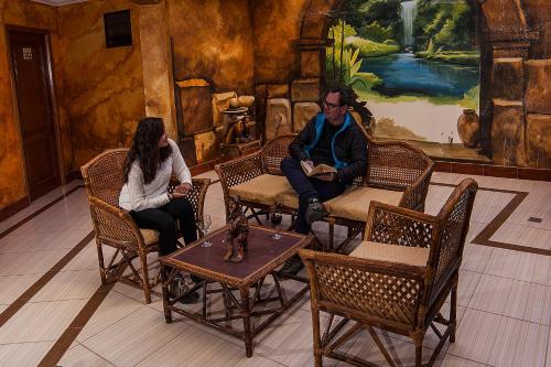 a man and a woman sitting in chairs in a room at Hotel Lago Azul in Copacabana