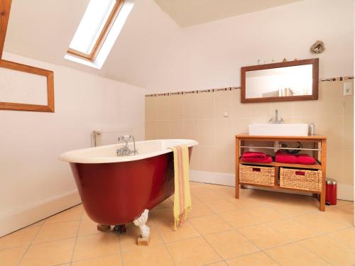 a large red bath tub in a bathroom with a sink at Chateau du Pont Jean in Fresse-sur-Moselle