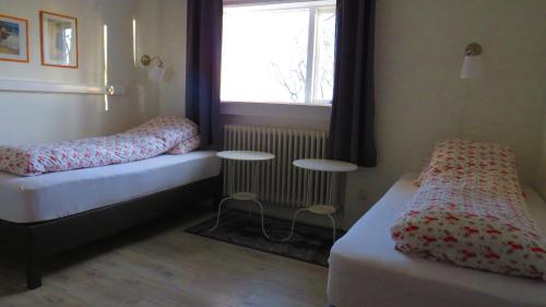 a small room with two beds and a window at Guesthouse Kálfafellsstadur in Kálfafellsstaður