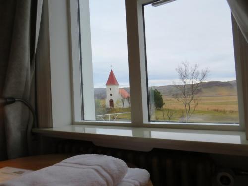 a window with a view of a church seen through it at Guesthouse Kálfafellsstadur in Kálfafellsstaður